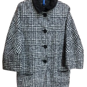 May include: A monochrome plaid coat featuring a black collar and four large black buttons. The coat has two front pockets and three-quarter length sleeves. It is suspended from a blue hanger.