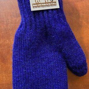 K&ouml;nnte beinhalten: Ein Paar blaue Alpaka-Wollhandschuhe mit einem Etikett mit der Aufschrift "Mother Nature's Finest Fiber" und "Made with Pride in the U.S.A. by the N.E. Alpaca Fiber Pool Inc."
