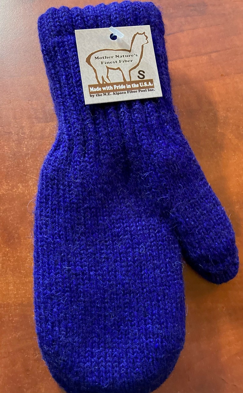 K&ouml;nnte beinhalten: Ein Paar blaue Alpaka-Wollhandschuhe mit einem Etikett mit der Aufschrift "Mother Nature's Finest Fiber" und "Made with Pride in the U.S.A. by the N.E. Alpaca Fiber Pool Inc."