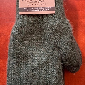 K&ouml;nnte beinhalten: Gr&uuml;ner Alpaka-Wollhandschuh mit einem braunen Etikett mit der Aufschrift "Mother Nature's Finest Fiber USA Alpaca Made in the USA with U.S. Grown Alpaca" und einem Gr&ouml;&szlig;enetikett "S".