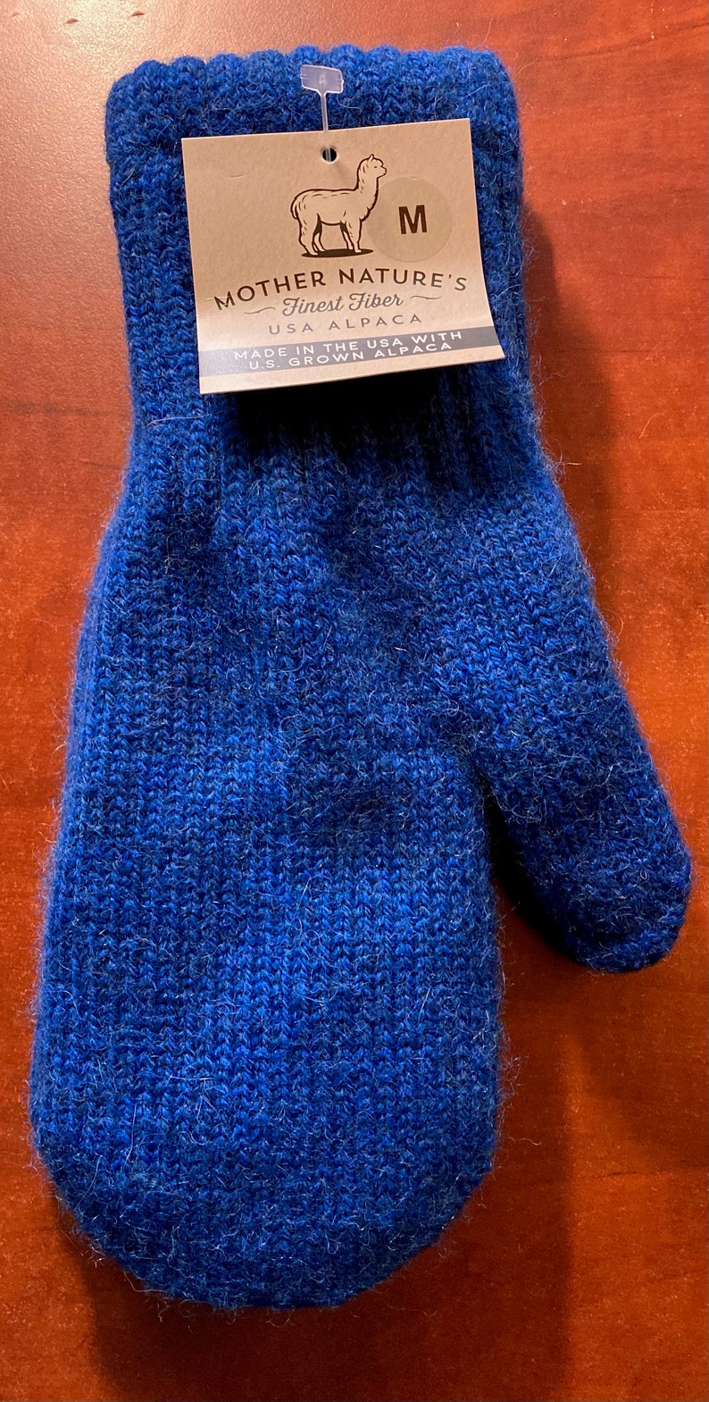 K&ouml;nnte beinhalten: Blaue Alpaka-Wollm&uuml;tze mit einem braunen Etikett mit der Aufschrift "Mother Nature's Finest Fiber USA Alpaca Made in the USA with U.S. Grown Alpaca" und einem Gr&ouml;&szlig;enetikett "M".