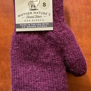 K&ouml;nnte beinhalten: Lilafarbener Alpaka-Wollhandschuh mit einem Etikett mit der Aufschrift "Mother Nature's Finest Fiber - USA Alpaca - Made in the USA with U.S. Grown Alpaca" und einem Gr&ouml;&szlig;enetikett "S".