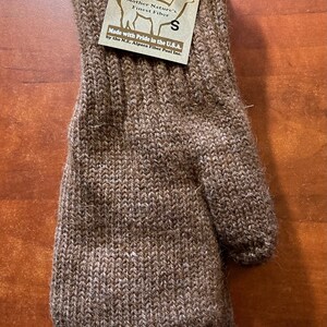 K&ouml;nnte beinhalten: Braune Alpaka-Wollm&uuml;tze mit einem Etikett mit der Aufschrift "Mother Nature's Finest Fiber" und "Made with Pride in the U.S.A. by the N.E. Alpaca Fiber Pool Inc."
