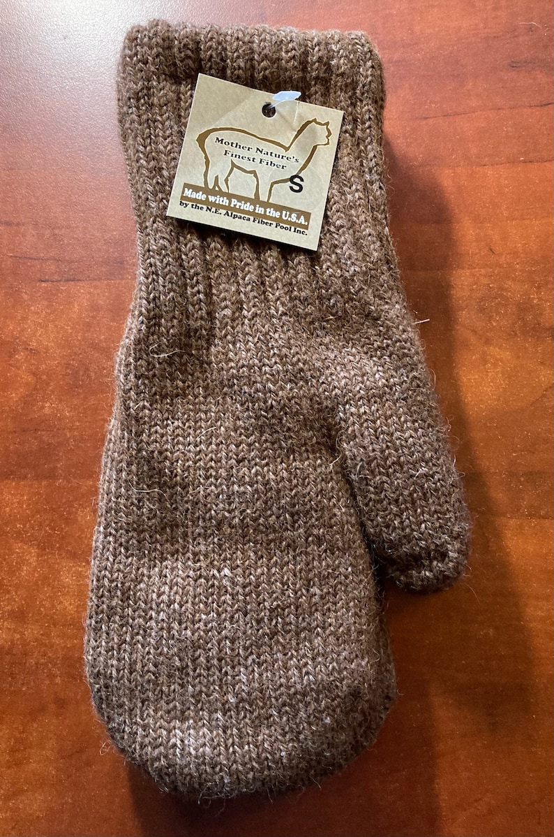 K&ouml;nnte beinhalten: Braune Alpaka-Wollm&uuml;tze mit einem Etikett mit der Aufschrift "Mother Nature's Finest Fiber" und "Made with Pride in the U.S.A. by the N.E. Alpaca Fiber Pool Inc."