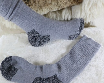 May include: Two pairs of gray wool socks with black accents. The socks have a ribbed texture and are designed for warmth and comfort.