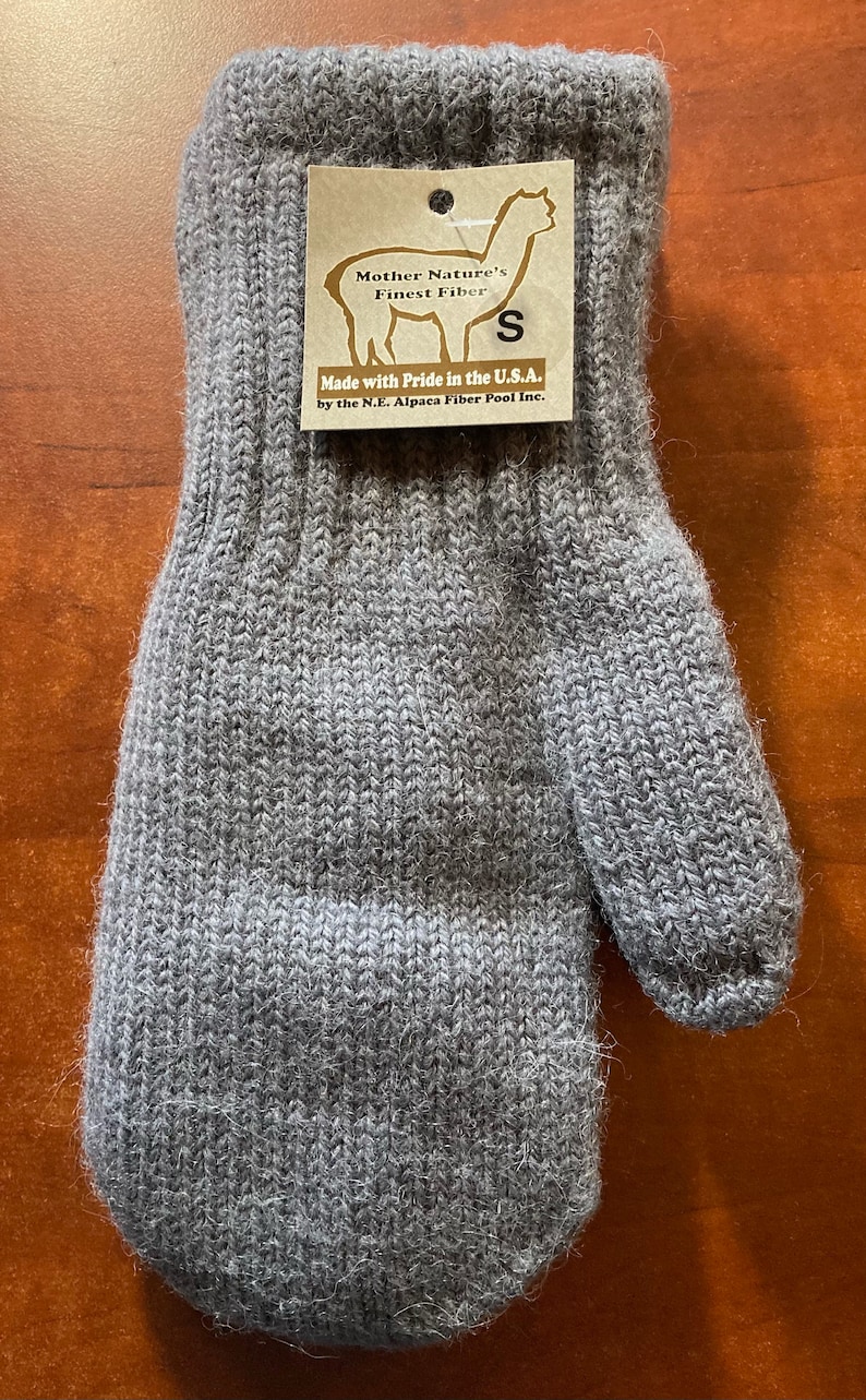 K&ouml;nnte beinhalten: Graue Alpaka-Wollhandschuhe mit einem braunen Etikett mit der Aufschrift "Mother Nature's Finest Fiber" und "Made with Pride in the U.S.A. by the N.E. Alpaca Fiber Pool Inc."