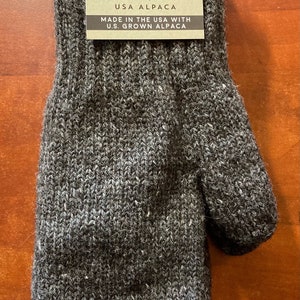 K&ouml;nnte beinhalten: Graue Alpaka-Wollhandschuhe mit einem Etikett mit der Aufschrift "Mother Nature's Finest Fiber USA Alpaca Made in the USA with U.S. Grown Alpaca" und einem Gr&ouml;&szlig;enetikett "S".