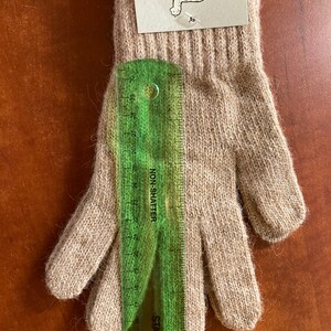 May include: A pair of beige alpaca gloves with a size M tag attached. The tag reads "Mother Nature's Finest Fiber".
