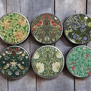 Pode incluir: Seis  tapetes redondos com uma borda prateada e uma variedade de padrões florais e de pássaros em tons de verde, vermelho, branco e azul.