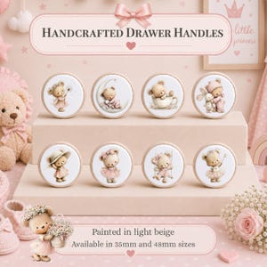 Pode incluir: Oito puxadores de gaveta redondos de madeira em bege claro, cada um com uma ilustração única de um ursinho em tons pastel suaves. O texto Handcrafted Drawer Handles é exibido acima, com Painted in light beige e tamanhos de 35mm e 48mm.