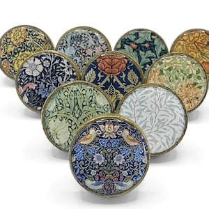 Peut inclure: Un ensemble de dix boutons ronds pour armoire de couleur laiton avec une variété de motifs floraux et de feuilles dans des tons de bleu, vert, jaune et rouge.