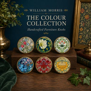 May include: Six round furniture knobs featuring William Morris floral patterns in various colors including red, blue, yellow, and green, each with a gold-toned metal rim, displayed on a wooden block with text reading William Morris The Colour Collection.