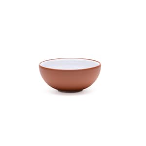 Op de afbeelding: Een kleine, ronde kom met een gladde, matte terracotta-kleurige buitenkant en een contrasterende glanzend witte binnenkant. De kom heeft een eenvoudig, gebogen silhouet met een brede opening en een platte bodem voor een strak ontwerp.