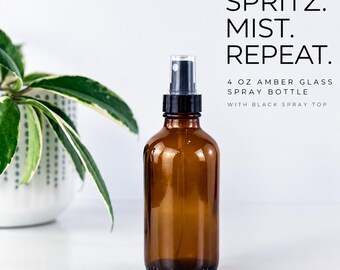 May include: A 4 oz amber glass spray bottle with a black spray top. The text on the image reads: SPRITZ. MIST. REPEAT. 4 OZ AMBER GLASS SPRAY BOTTLE WITH BLACK SPRAY TOP. The bottle is clear, brown, and features a functional pump mechanism.