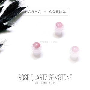 May include: Three pink rose quartz gemstone rollerball inserts. The inserts are on a white background.  KARMA + COSMO.