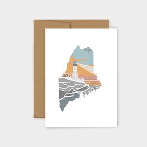 May include: A white card with a brown envelope. The card features a white outline of the state of Maine with a lighthouse and a sunset sky inside the outline.