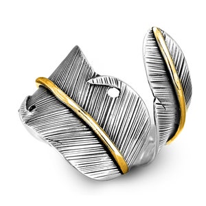 May include: A silver ring with a feather design. The feather is detailed with a gold line down the center.