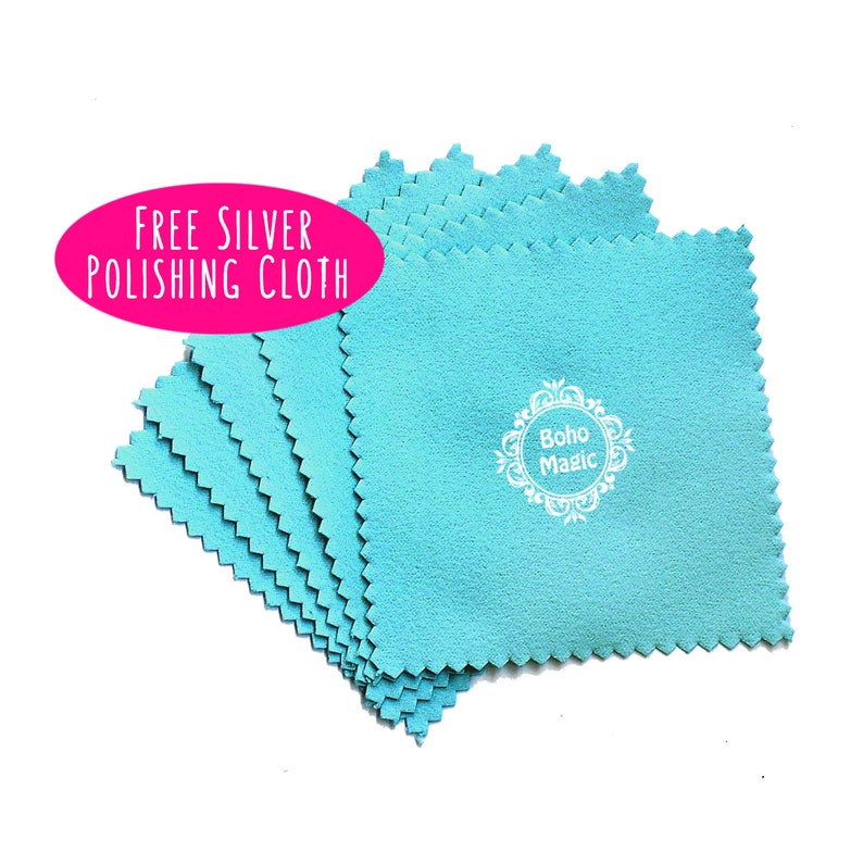 May include: A stack of six turquoise blue microfiber polishing cloths with a white logo that says "boho magic" in a decorative circle. The text "Free Silver Polishing Cloth" is in a pink circle.