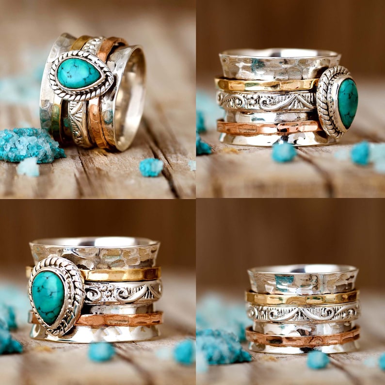 May include: A silver spinning ring with a turquoise gemstone. The ring has multiple bands of silver, copper, and gold.