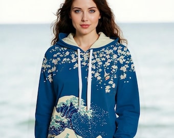 May include: A blue hoodie featuring a Japanese wave design and cherry blossoms. The hoodie has a cream-colored hood lining and white drawstrings. The design covers the front and sleeves of the hoodie.