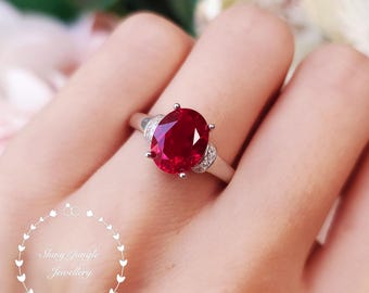 Anillo de compromiso con rubí sintético genuino de 3 quilates de talla ovalada y diseño de cinta, anillo de promesa de piedra natal de julio, chapado en oro blanco/rosa.