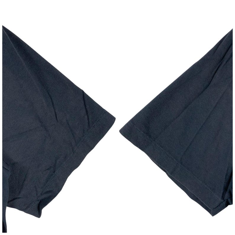 Pu&ograve; includere: Primo piano di due maniche corte blu navy scuro di una t-shirt. Le maniche sono realizzate in un tessuto morbido e strutturato e sono su uno sfondo bianco. Le cuciture sono visibili.