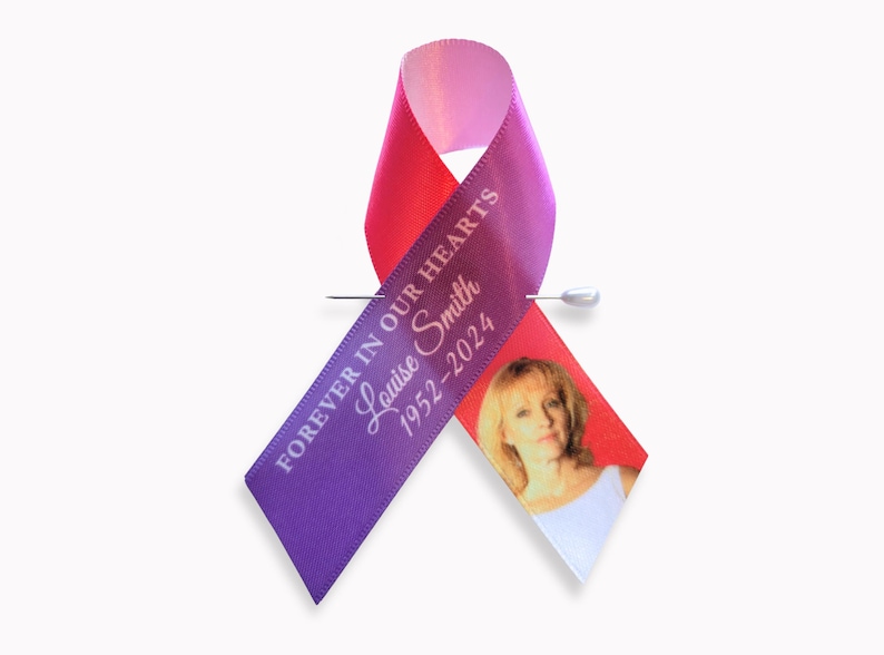 Peut inclure: Un ruban de sensibilisation violet et rose avec un message comm&eacute;moratif imprim&eacute; en blanc indiquant FOREVER IN OUR HEARTS, le nom Louise Smith et les ann&eacute;es 1952-2024. Une petite photo d'une personne est imprim&eacute;e sur le pan droit du ruban.