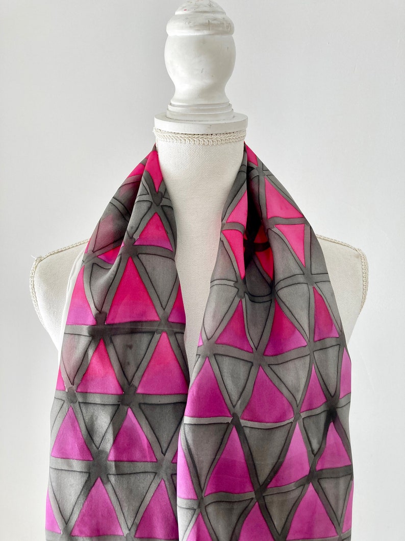 Hand-painted silk scarf with laticular geometry design consisting of triangles in gray purple and magenta.