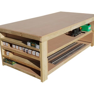 May include: A wooden workbench with three shelves and a large work surface. The shelves are filled with small boxes and the bottom shelf has metal rods.