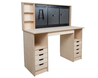 May include: A light-colored wooden desk with a black pegboard back and multiple drawers. The desk has a large work surface, a shelf, and several drawers for storage. The pegboard has a grid pattern and is mounted above the desk.