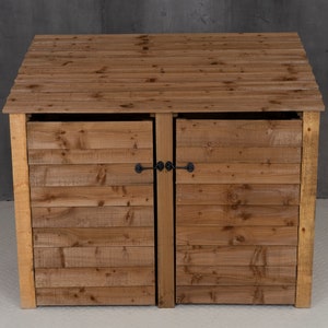 May include: A wooden double-door bin storage unit with a hinged lid. The bin has a natural wood finish and black metal latches.