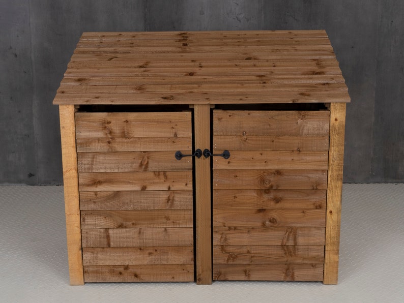 May include: A wooden double-door bin storage unit with a hinged lid. The bin has a natural wood finish and black metal latches.