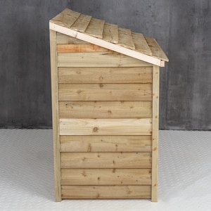 May include: Side view of a wooden storage shed with a slanted roof. The shed is made of natural wood with a light brown color.