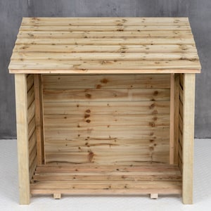 May include: A wooden log storage shed with a slanted roof and a slatted front. The shed is empty and ready to be filled with firewood.