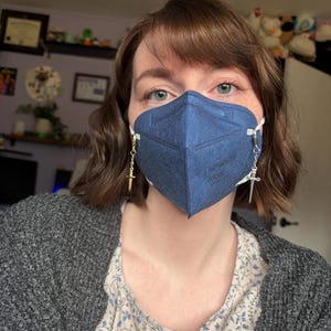 May include: A set of three ceramic mugs with a speckled, matte finish. Each mug is a different colour: light blue, cream, and grey. The mugs have a simple, modern design with a rounded shape and a comfortable handle.