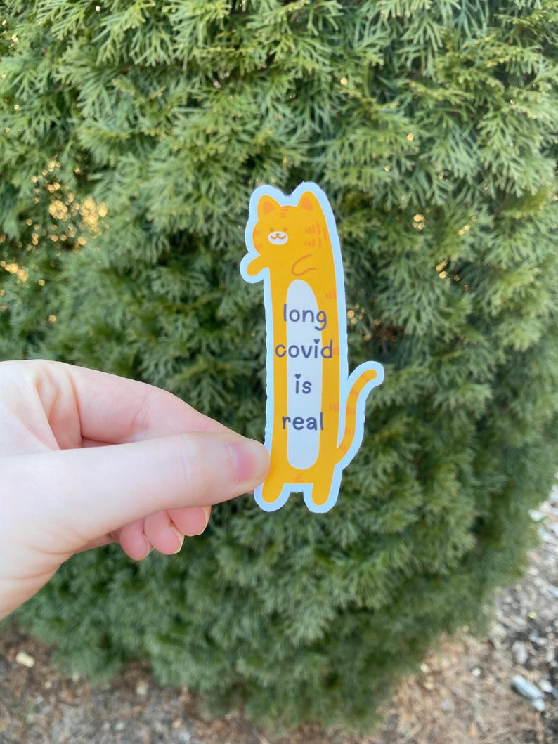 May include: A yellow cartoon cat sticker with the text "long covid is real".