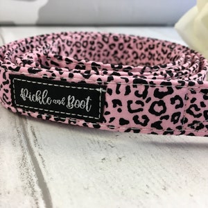 May include: Pink and black leopard print dog collar with a black label that says "Pickle and Boot".