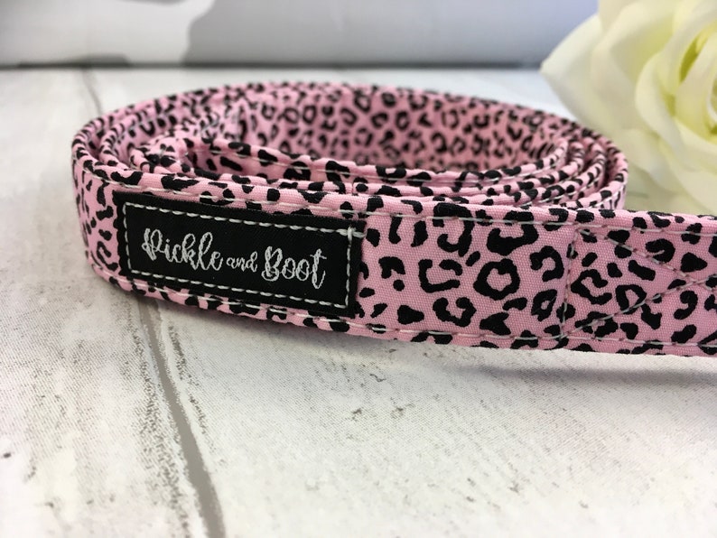 May include: Pink and black leopard print dog collar with a black label that says "Pickle and Boot".
