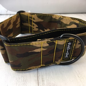 May include: A camouflage dog collar with yellow stitching and a black metal buckle. The collar has the text "Ruff &  Woof" embroidered on it.