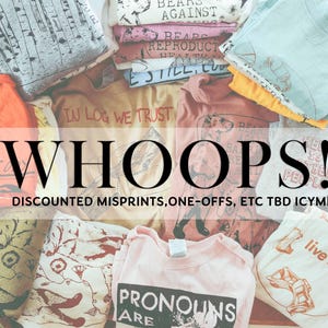 Puede incluir: Una pila de camisetas con varios diseños y lemas, incluyendo "In Log We Trust", "Bears Against Reproductive Health", "Still, Cute", "The Is Their People", y "Live Laugh Love". El texto "WHOOPS! DISCOUNTED MISPRINTS, ONE-OFFS, ETC TBD ICYMI" se muestra en la parte superior de la imagen.