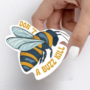 Könnte beinhalten: Ein weißer Aufkleber mit einer Cartoon-Biene und dem Text "Don't Kill A Buzz Kill" in gelben und orangen Buchstaben.