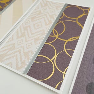 May include: A collection of decorative cards with various patterns. The designs include geometric shapes, gold circles, and textured backgrounds in shades of brown, beige, and white. Each card is bordered with a white frame and a gray trim.