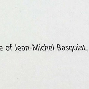 May include: Text on a white background reads: "- &copy; The Estate of Jean-Michel Basquiat, New York." The text is in a simple, sans-serif font. The image is a close-up shot.
