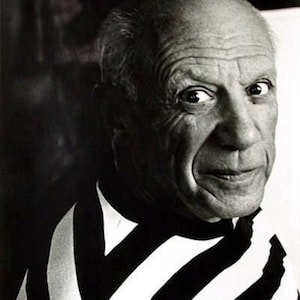 Op de afbeelding: Zwart-wit portret van Pablo Picasso, met een gestreept shirt. Het Apple-logo en de tekst "Think different" zijn zichtbaar. Dit is een promotieafbeelding.