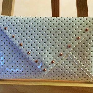 White perforated lacquered vinyl pocket envelope