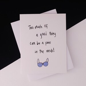 May include: A white card with black handwritten text that reads "Too much of a good thing can be a pain in the neck!" and a blue bra illustration.