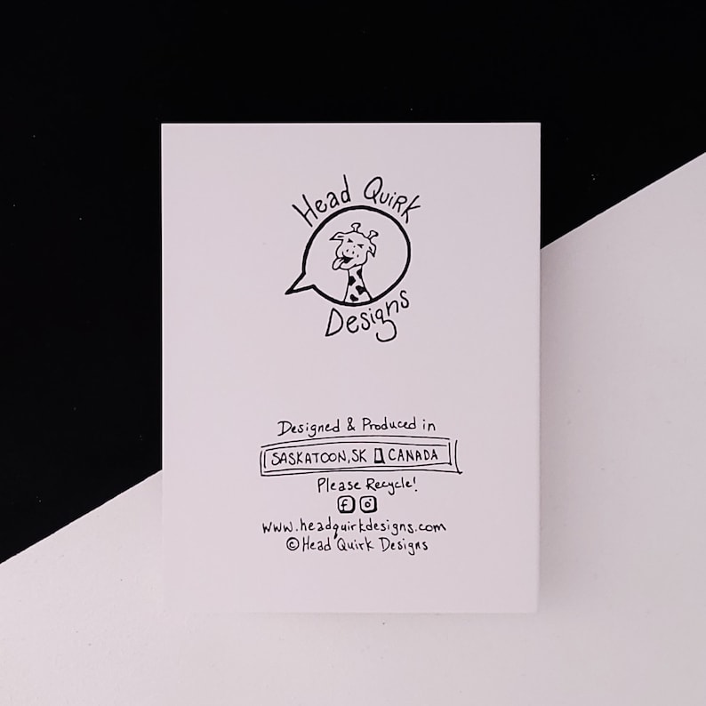 May include: A white card with black text and a cartoon giraffe in a speech bubble. The text reads "Head Quirk Designs", "Designed & Produced in Saskatoon, SK Canada", "Please Recycle!" and "www.headquirkdesigns.com". The card also includes social media icons for Facebook and Instagram.