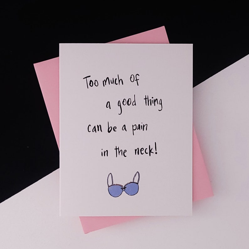 May include: A white card with black text that reads "Too much of a good thing can be a pain in the neck!" and a cartoon illustration of a blue bra.