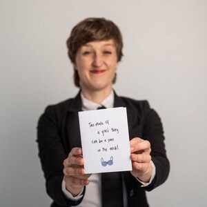 May include: A white card with the text "Too much of a good thing can be a pain in the neck!" and a blue illustration of a bra.
