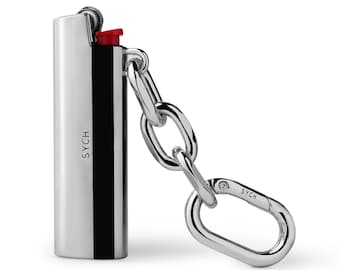 May include: A silver lighter with a red button and a silver chain attached to a silver carabiner. The lighter has the word "SYCH" engraved on the side.